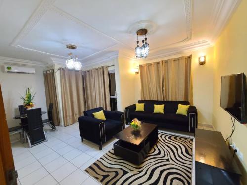 a living room with a couch and a table at LUXOR RESIDENCE YASSA DOUALA in Ngori