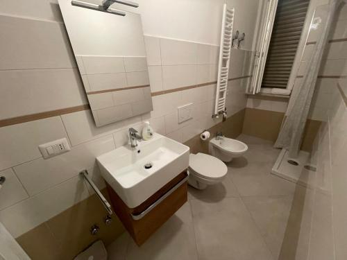 a bathroom with a sink and a toilet and a mirror at La Dimora del Maggio in Accettura
