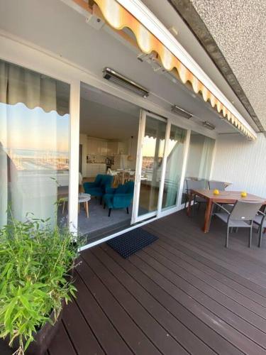 a deck with a table and chairs on a house at Panoramablick und den Strand direkt vor der Tür in Kiel