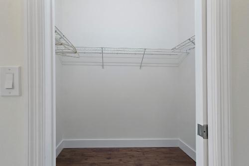 a hallway with a white wall with a shelf on the ceiling at Jupiter's Beacon Villa in Jupiter
