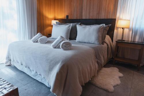 um quarto com uma cama grande e toalhas em Vila Master Familiar en Las Pendientes em San Martín de los Andes