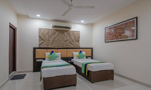 a bedroom with two beds and a air conditioner at Treebo Emerald in Hyderabad