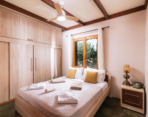 sypialnia z dużym łóżkiem i oknem w obiekcie Wooden Beach House w mieście Gerani