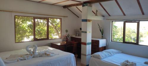 a bedroom with two beds and two windows at Flor's House in San Cristobal