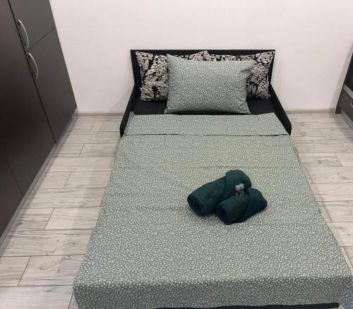 a bed with a green stuffed animal on it at Ultra Lux Studio Free Underground Parking in Pazardzhik