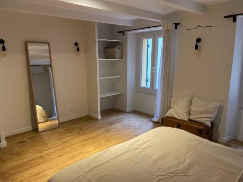 une chambre avec un lit et un miroir dans l'établissement Charmant studio Vauban, à Marseille
