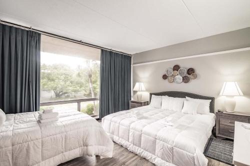 a bedroom with two beds and a large window at Litchfield Retreat near Brookgreen Gardens in Pawleys Island