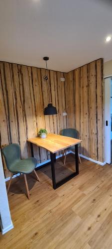 a dining room with a wooden table and two chairs at Jedermanns Nest in Nümbrecht