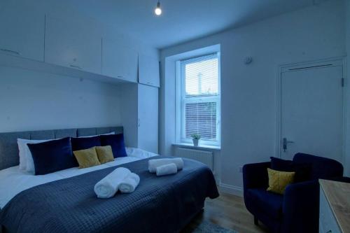 Excellent One Bedroom Apartment Dundee في دندي: غرفة نوم عليها سرير وفوط بيضاء