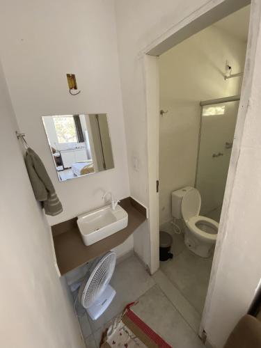 a bathroom with a toilet and a sink and a mirror at Chalés Paradise - Casal in Serra do Cipo