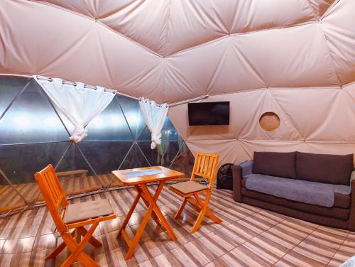 ein Zimmer mit einem Sofa und einem Tisch in einem Zelt in der Unterkunft Las Colinas Glamping in Turrialba