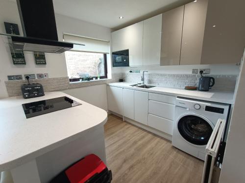 a kitchen with a washing machine and a washer at Grace's Place in Soham in Soham