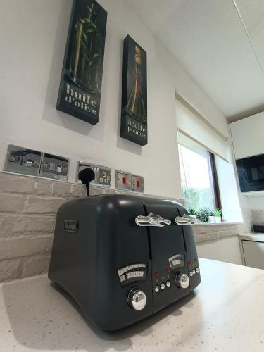 a black toaster sitting on a counter in a kitchen at Grace's Place in Soham in Soham
