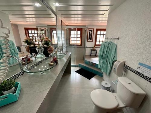 a bathroom with a sink and a toilet at Casa de CINEMA 3 suites, 50m da Praia da Ferradura in Búzios