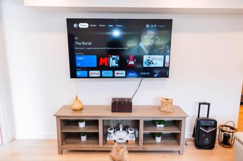 a living room with a tv on the wall at Riverfront Cottage Canoe Included & Playroom Fun in Wasaga Beach