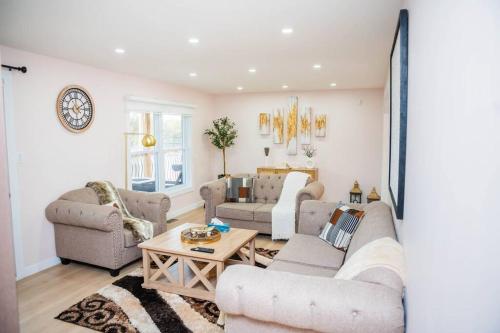 a living room with two couches and a table at Riverfront Cottage Canoe Included & Playroom Fun in Wasaga Beach