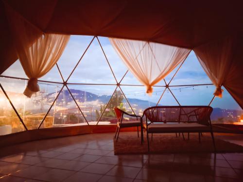 a room with two chairs in front of a large window at Las Colinas Glamping in Turrialba