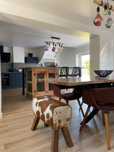 une cuisine avec une table en bois et une salle à manger dans l'établissement Clos de la Lainerie, à Gouville-sur-Mer