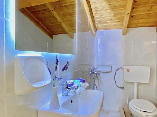 a bathroom with a white sink and a toilet at Villa Doma with private pool for up to 29 guests by DadoVillas in Roda