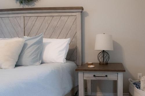 a bedroom with a bed and a table with a lamp at Texas Roots: King Beds and Modern Comfort in McKinney