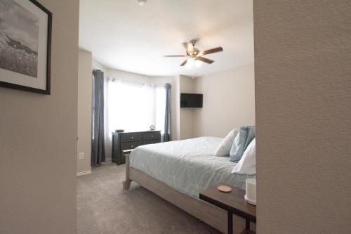 a bedroom with a bed and a ceiling fan at Texas Roots: King Beds and Modern Comfort in McKinney