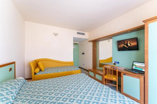 a bedroom with a bed and a desk and a television at Hotel Villa Elena in Tortoreto Lido