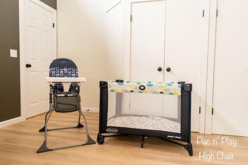 a baby crib and a high chair in a room at Vineyards Edge - Pool, Hot Tub, Bikes- 1mi to Downtown in Healdsburg