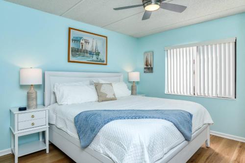 - une chambre bleue avec un lit et une fenêtre dans l'établissement Ocean and Racquet 8208, à Saint Augustine