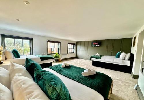 una gran sala de estar con un sofá blanco y almohadas verdes en Burton Manor-Sleeps 16 in Burton Town Centre en Burton upon Trent