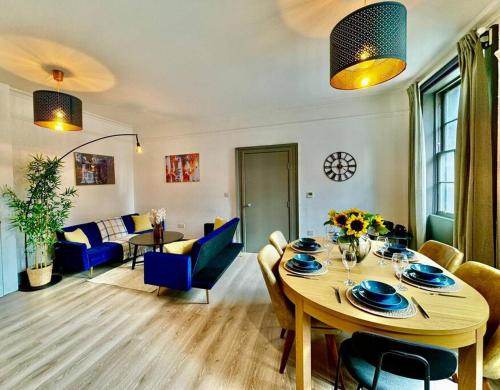 sala de estar con mesa y sillas azules en Burton Manor-Sleeps 16 in Burton Town Centre en Burton upon Trent