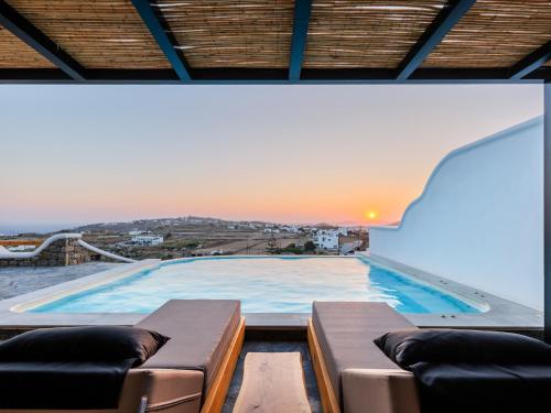 a large swimming pool with two couches on a roof at Evi Suites & Villas in Mikonos