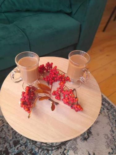 a table with two glasses and berries on it at Emotion Kazbegi in Stepantsminda