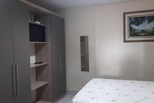 a bedroom with a bed and a flat screen tv at Kitinet Central in Belo Horizonte