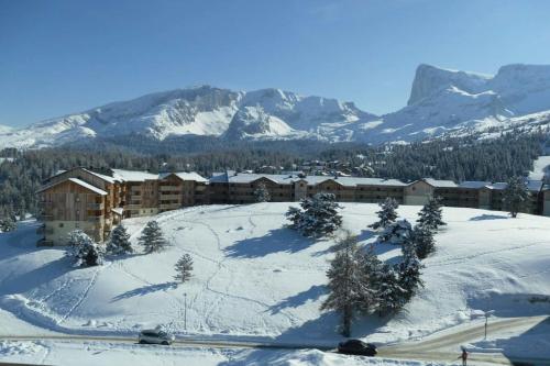 a resort in the snow with mountains in the background at Super Devoluy Cosy apartment close to the slopes in Le Dévoluy