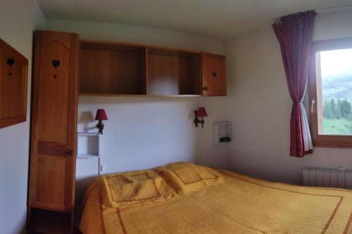 a small bedroom with a bed and a window at Super Devoluy Cosy apartment close to the slopes in Le Dévoluy