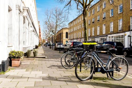 dwa rowery zaparkowane na chodniku przy ulicy miejskiej w obiekcie Cosy Marylebone Flat w Londynie