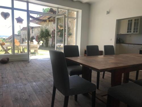 a dining room with a wooden table and chairs at Gite tout confort - Vexin - Val d'Oise in Frémainville