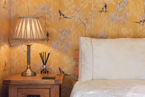 a bedroom with a bed and a lamp on a night stand at The Bell Lodge in Sandown