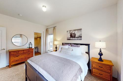 a bedroom with a bed and a dresser and a mirror at Cottonwood Pass Retreat in Gypsum