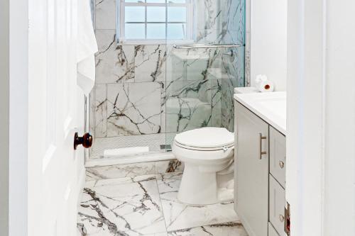 a white bathroom with a toilet and a shower at Seminole's Secret in Redington Shores