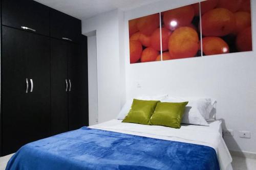 1 dormitorio con 1 cama y una pintura de naranjas en Near the UIS, stadium, la mercy clinic WIFI 225Mbp en Bucaramanga
