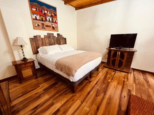 a bedroom with a bed and a flat screen tv at Hotel Jireh in San Pedro de Atacama