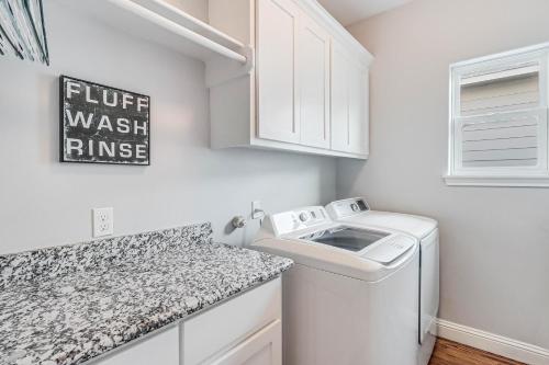 a white laundry room with a washer and dryer at The Blue Shell in Port Aransas