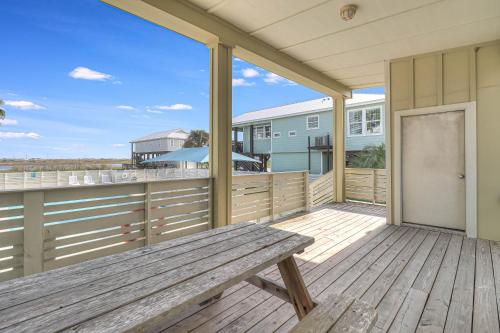 a wooden porch with a bench on a deck at The Blue Shell in Port Aransas