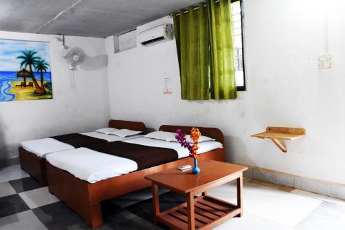 ein Schlafzimmer mit einem Bett und einem Tisch mit Blumen darauf in der Unterkunft Caasa De Nirvana by OceanSide 4 Guest in Velha Goa