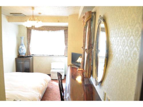 a bedroom with a dressing table and a mirror at Green Hotel Rich Tokugawaen - Vacation STAY 02720v in Okazaki
