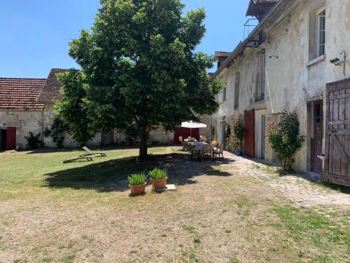 a yard with a tree next to a building at Gite tout confort - Vexin - Val d'Oise in Frémainville