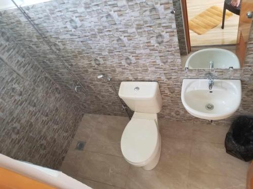 a bathroom with a white toilet and a sink at JSS PENSION HOUSE 