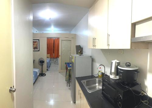 a small kitchen with a sink and a refrigerator at Sea Residences - Manila Pasay near MOA by Ipe in Manila
