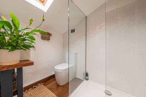 a bathroom with a toilet and a glass shower at Most romantic cottage in Suffolk - Number Four in Framlingham